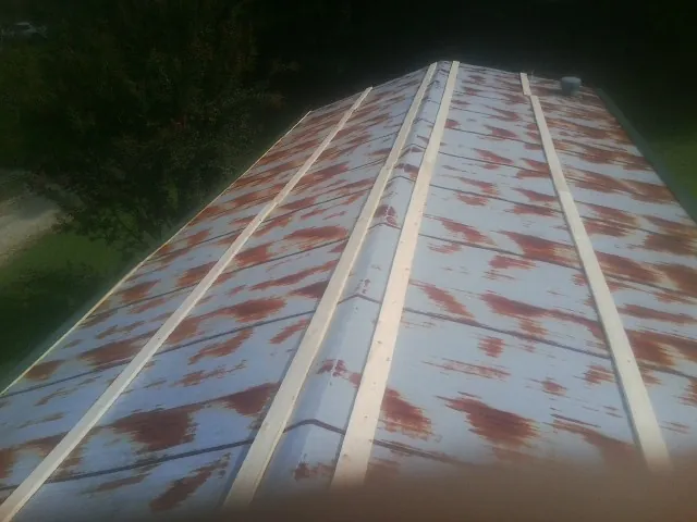 Rusted metal roof panels with new wood purlins before replacement — Storm Damage Roof Repair in Laketon by Roofing Brothers