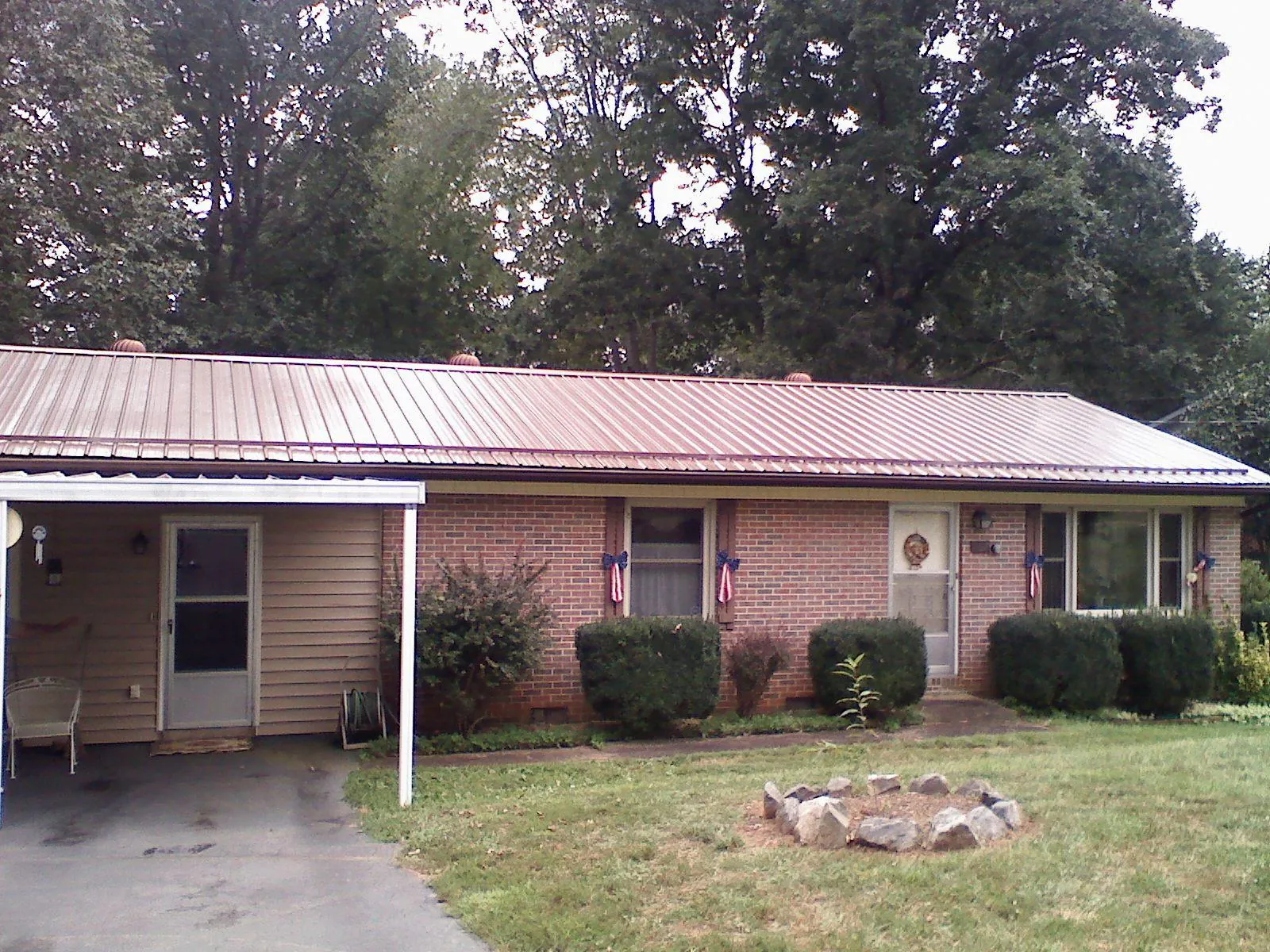 Bronze metal roof and carport on a brick ranch home — Roof Repair work by our crew in Laketon