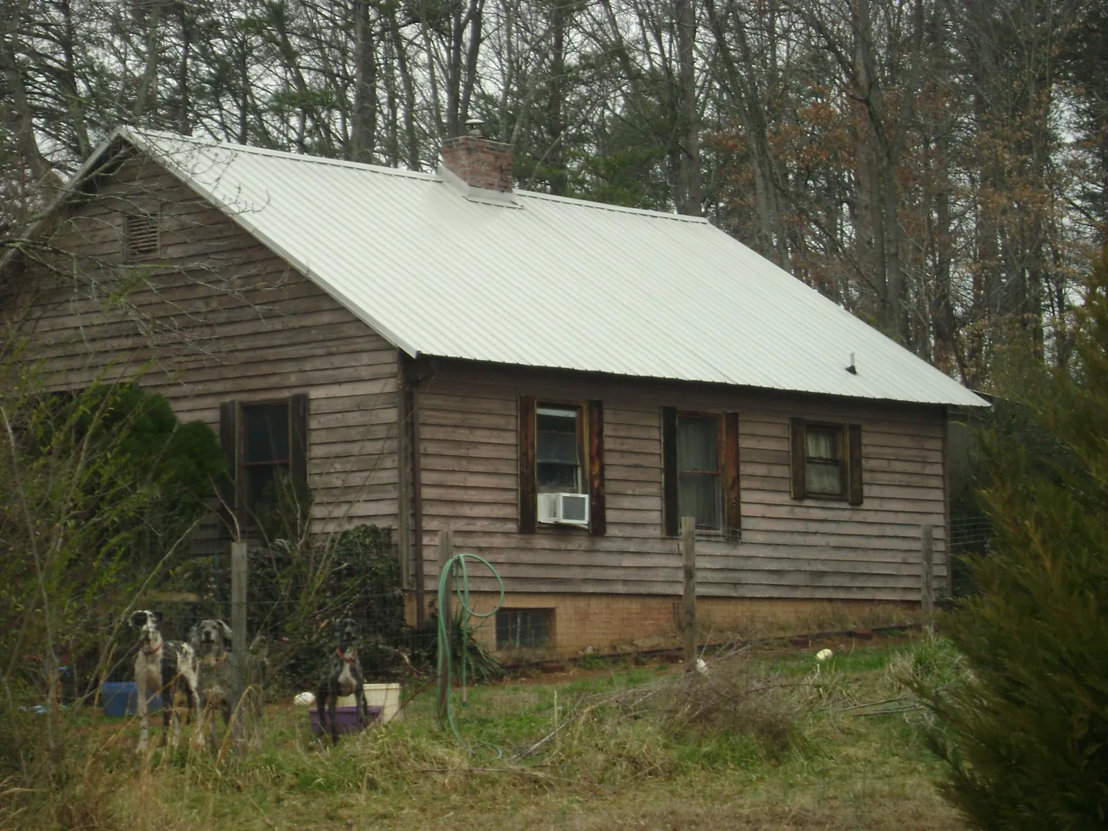 White metal roof on an old wood sided farmhouse, from a Metal Roof Installation job in Laketon