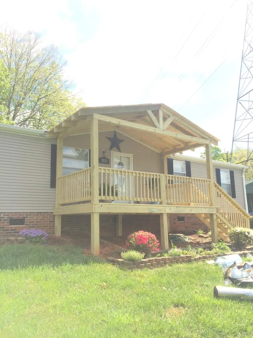 New gabled porch roof and deck railing added to a ranch home in Laketon